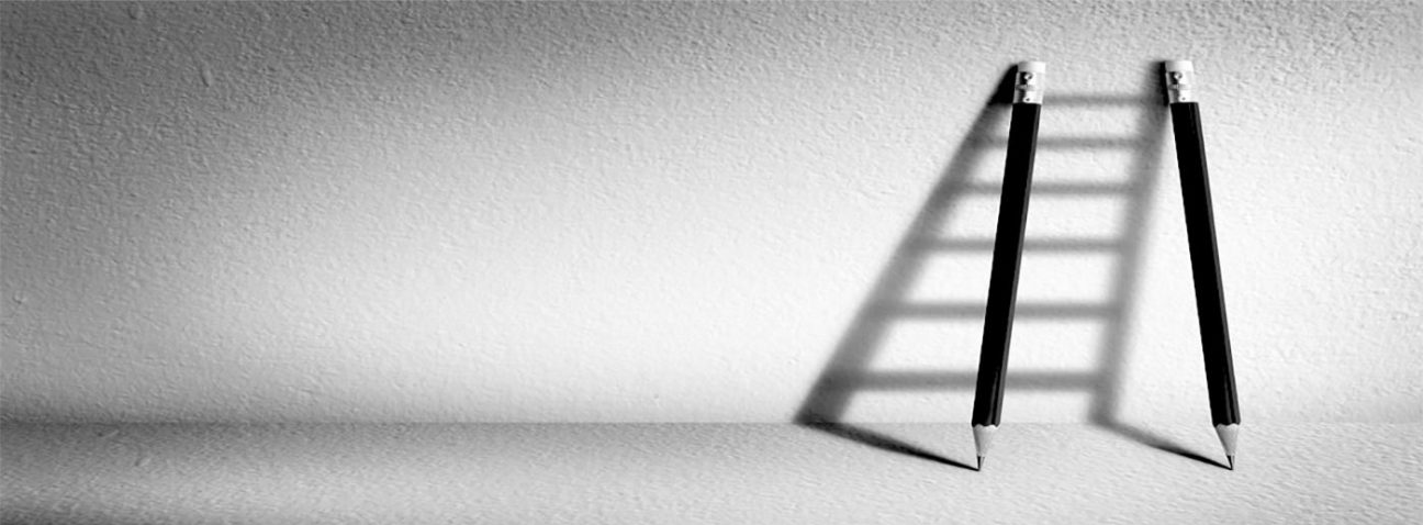 Two pencils leaning on a wall with their shadows making a shadow ladder